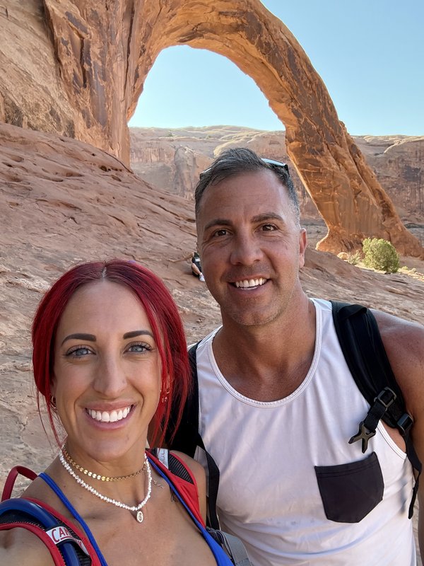 Cheyenne and family hiking beneath a desert arch in Utah
